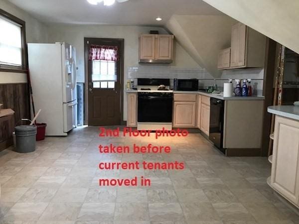 2 Hammond Ct, Quincy, MA 02169 - kitchen with black appliances, light brown cabinetry, light countertops, and lofted ceiling