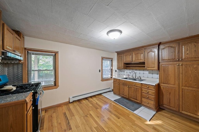 2 Hammond Ct, Quincy, MA 02169 - kitchen featuring gas stove, baseboard heating, under cabinet range hood, light wood-style flooring, and a sink