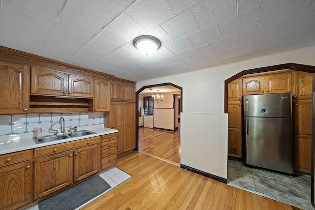 2 Hammond Ct, Quincy, MA 02169 - kitchen featuring freestanding refrigerator, a sink, arched walkways, and light wood-type flooring