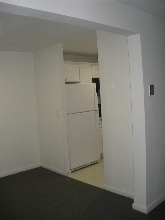 47 W St Unit A2, Randolph, MA 02368 - kitchen with freestanding refrigerator, baseboards, and white cabinets