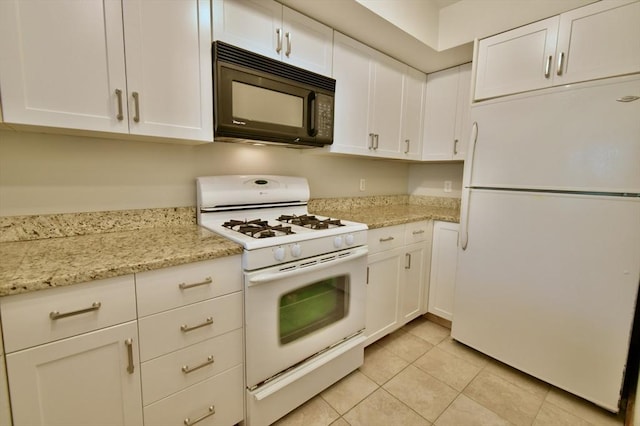 39 Bellis Cir Unit E, Cambridge, MA 02140 - kitchen featuring light stone counters, white cabinetry, light tile patterned floors, and white appliances