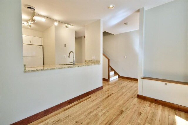 39 Bellis Cir Unit E, Cambridge, MA 02140 - unfurnished room with visible vents, baseboards, rail lighting, a sink, and light wood-style flooring