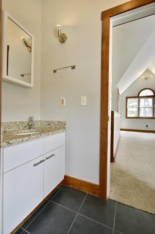 39 Bellis Cir Unit E, Cambridge, MA 02140 - bathroom with tile patterned floors, baseboards, vanity, and lofted ceiling