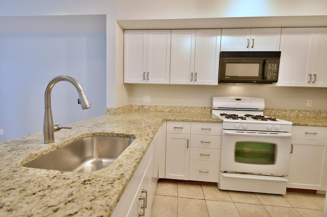 39 Bellis Cir Unit E, Cambridge, MA 02140 - kitchen featuring white cabinets, light tile patterned flooring, white gas range oven, black microwave, and a sink