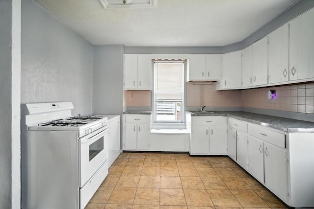 16 Laurel St, Springfield, MA 01107 - kitchen featuring white range with gas cooktop, a textured ceiling, white cabinetry, and decorative backsplash