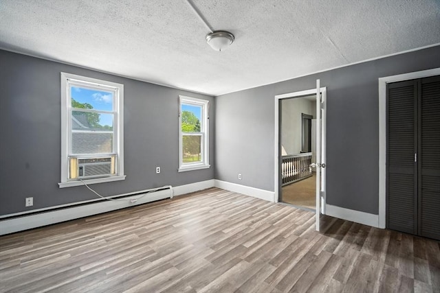 16 Laurel St, Springfield, MA 01107 - unfurnished bedroom featuring wood finished floors, a textured ceiling, a baseboard heating unit, cooling unit, and a closet