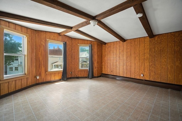 16 Laurel St, Springfield, MA 01107 - empty room with tile patterned floors, healthy amount of natural light, beamed ceiling, wooden walls, and a baseboard radiator