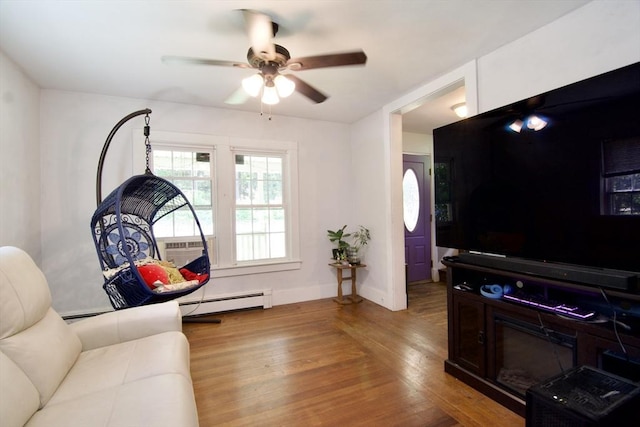 31 E St, Stafford, CT 06076 - living room with baseboard heating, wood finished floors, a ceiling fan, and a wall mounted air conditioner