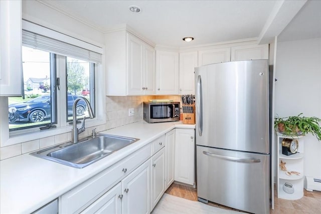 113 N Ridge Rd, Ipswich, MA 01938 - kitchen featuring stainless steel appliances, a sink, white cabinetry, light countertops, and tasteful backsplash