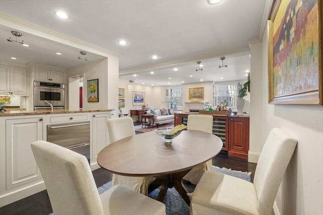 dining area with recessed lighting, beverage cooler, dark wood finished floors, and crown molding