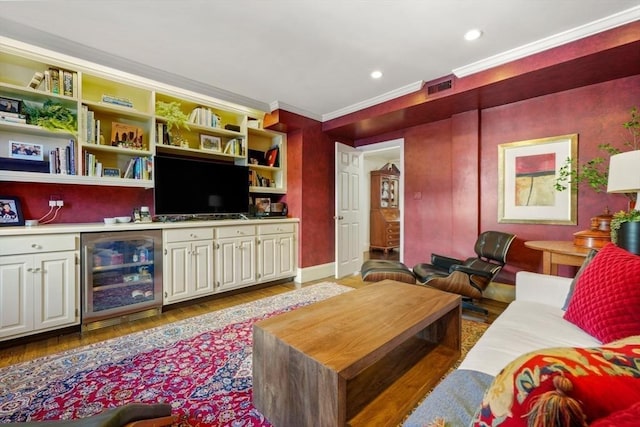 living room with visible vents, beverage cooler, ornamental molding, wood finished floors, and recessed lighting