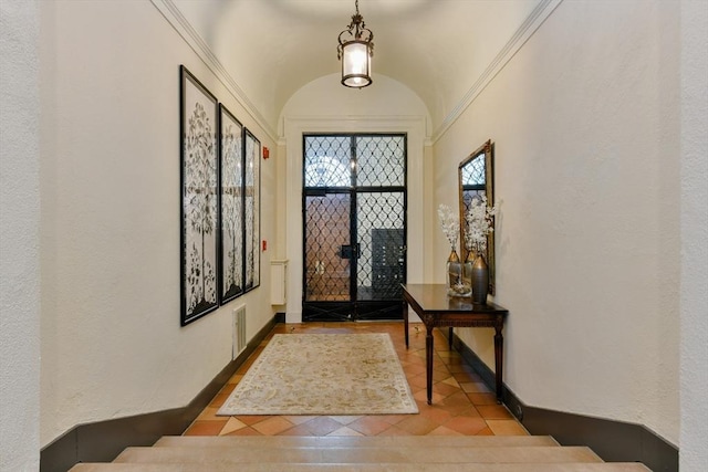 foyer with visible vents, lofted ceiling, and baseboards