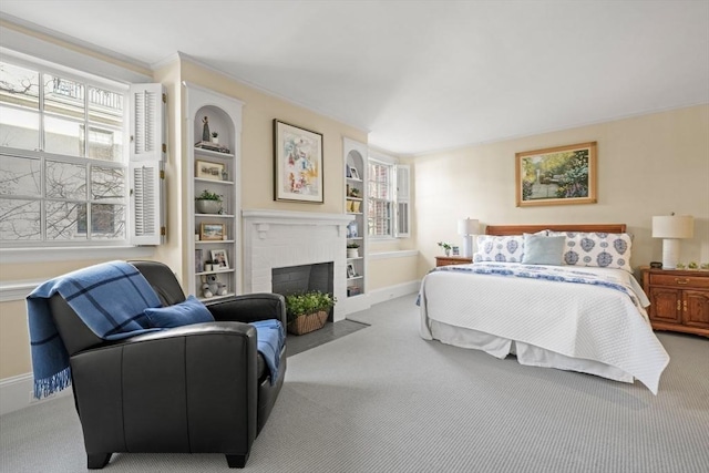 carpeted bedroom featuring a brick fireplace and baseboards