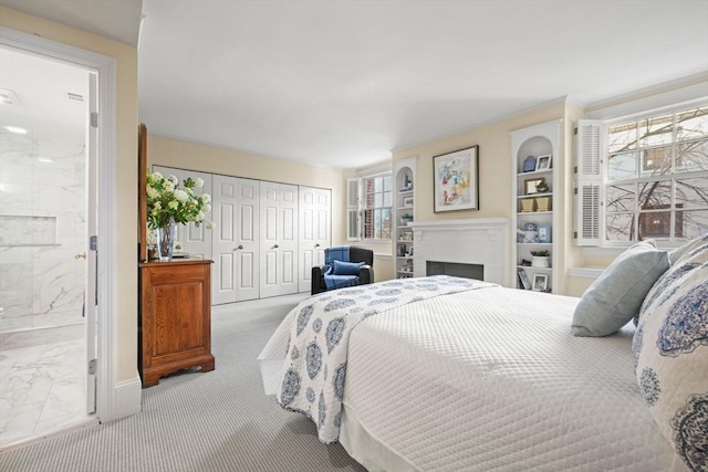 bedroom with a closet, marble finish floor, a fireplace, and ensuite bathroom