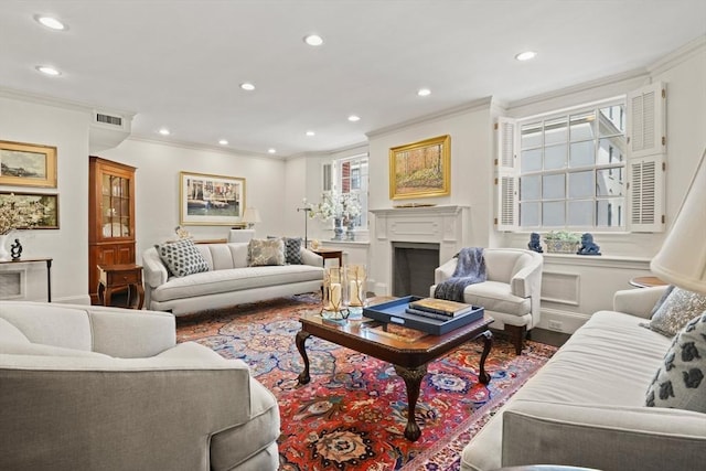 living room with recessed lighting, visible vents, ornamental molding, and a fireplace