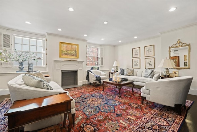 living room with recessed lighting, baseboards, a fireplace with flush hearth, and ornamental molding