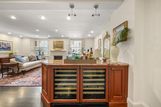 bar with wood finished floors, recessed lighting, a fireplace, and ornamental molding