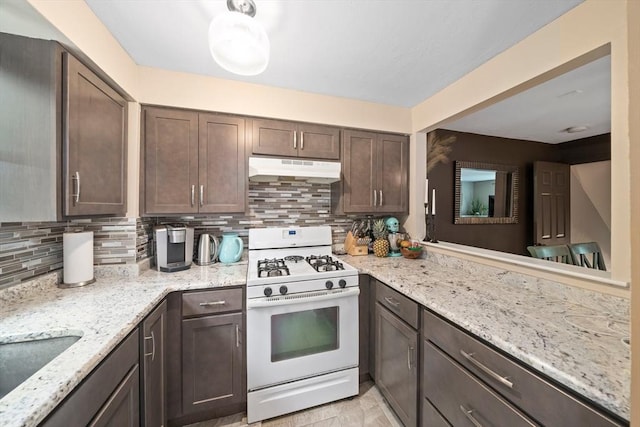 547 Washington St Unit B13, Pembroke, MA 02359 - kitchen featuring white range with gas cooktop, under cabinet range hood, dark brown cabinetry, backsplash, and light stone counters