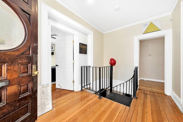 hall with ornamental molding and light hardwood / wood-style flooring