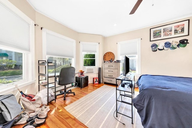 bedroom with hardwood / wood-style floors, ceiling fan, and cooling unit