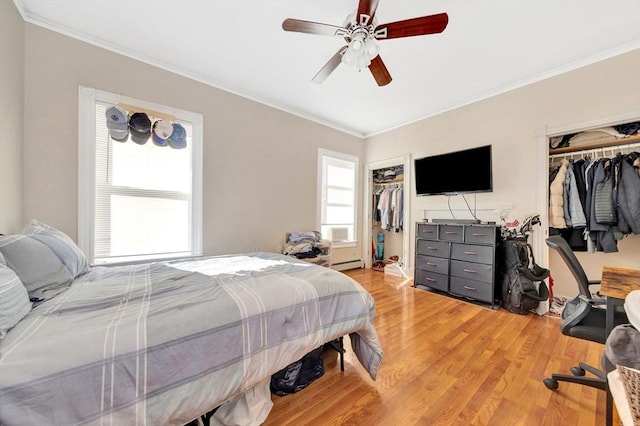 bedroom with ceiling fan, hardwood / wood-style floors, ornamental molding, a baseboard radiator, and a closet