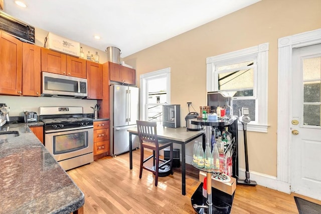 kitchen featuring appliances with stainless steel finishes, sink, and light hardwood / wood-style flooring