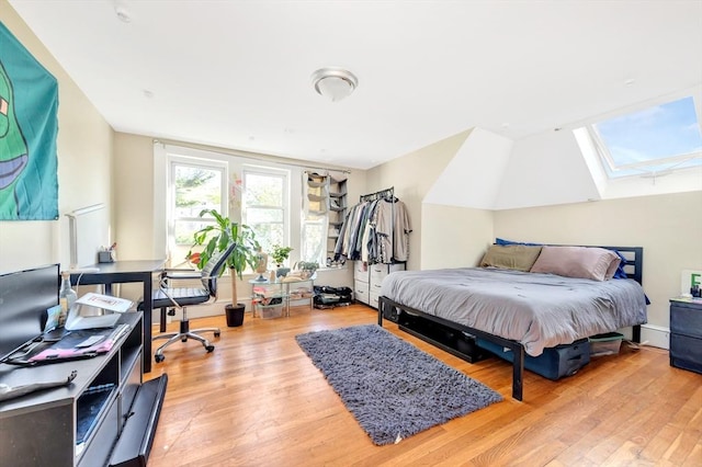 bedroom featuring hardwood / wood-style flooring and lofted ceiling with skylight