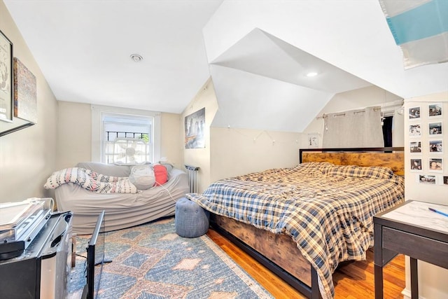 bedroom featuring vaulted ceiling and wood-type flooring