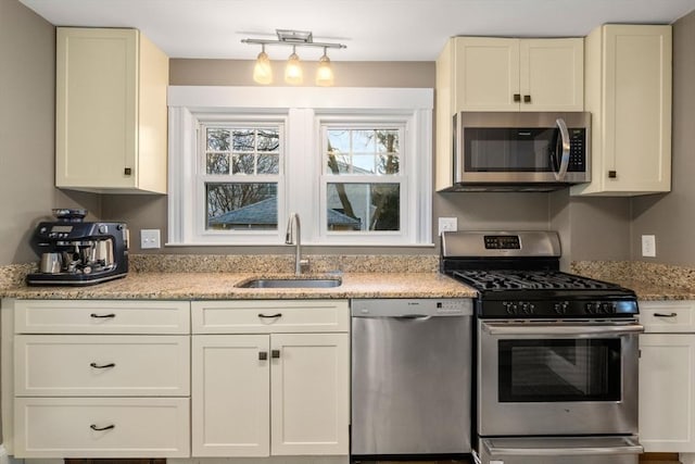 kitchen featuring sink, stainless steel appliances, and light stone countertops