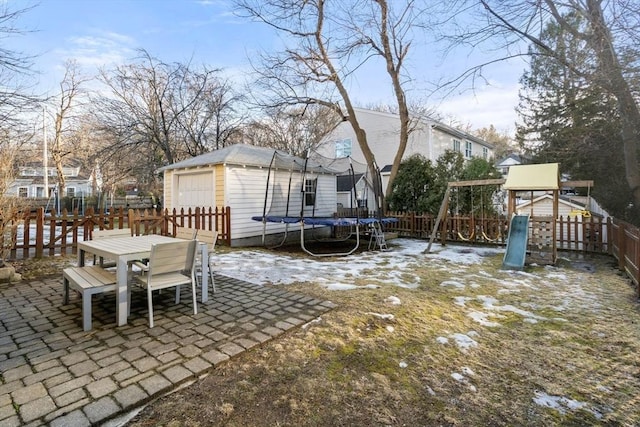 view of patio / terrace featuring a trampoline, a playground, and a shed