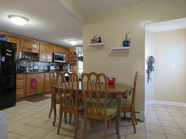 tiled dining room featuring sink and a textured ceiling