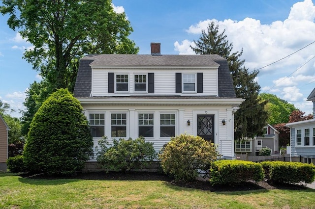 dutch colonial with a chimney and a shingled roof