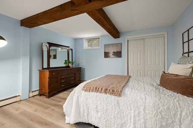 bedroom with wood finished floors, a baseboard heating unit, beamed ceiling, and a closet