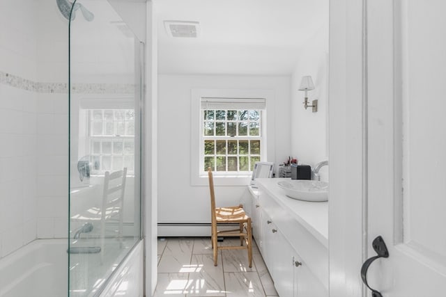 bathroom with tile patterned flooring, combined bath / shower with glass door, baseboard heating, and vanity