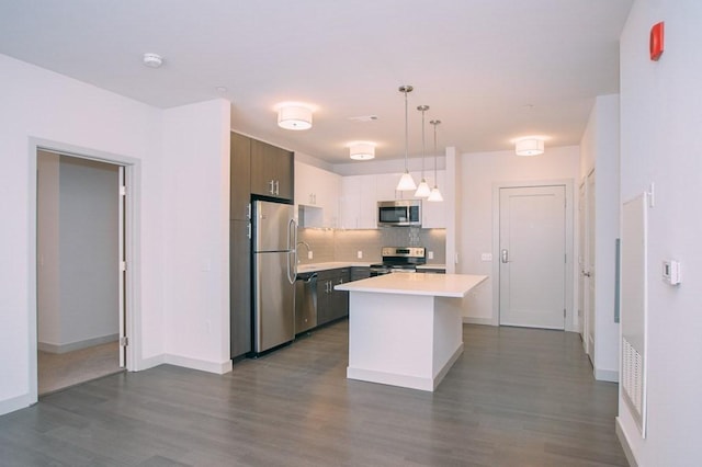 kitchen with a kitchen island, tasteful backsplash, dark wood finished floors, light countertops, and stainless steel appliances