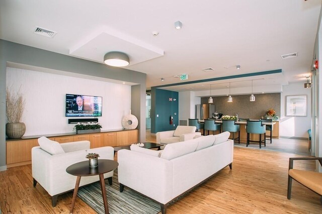 living area featuring visible vents and light wood-type flooring