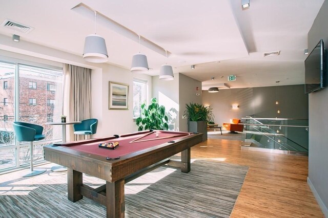 recreation room featuring visible vents, plenty of natural light, and wood finished floors