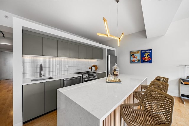 1313 Washington St Unit 309, Boston, MA 02118 - kitchen with appliances with stainless steel finishes, gray cabinetry, decorative backsplash, a breakfast bar area, and modern cabinets