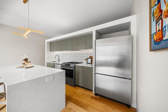 1313 Washington St Unit 309, Boston, MA 02118 - kitchen with appliances with stainless steel finishes, light wood-style flooring, backsplash, gray cabinets, and open shelves
