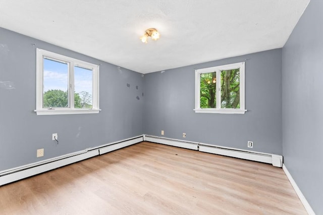 59 Harvard St, Everett, MA 02149 - unfurnished room featuring plenty of natural light, a baseboard heating unit, and wood finished floors