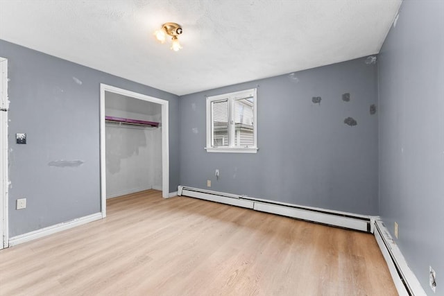59 Harvard St, Everett, MA 02149 - unfurnished bedroom featuring baseboard heating, light wood finished floors, and a closet