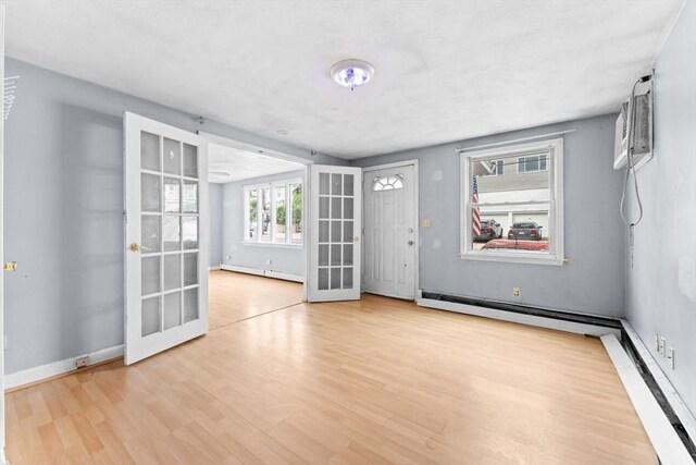 59 Harvard St, Everett, MA 02149 - spare room with baseboard heating, french doors, wood finished floors, and a baseboard radiator