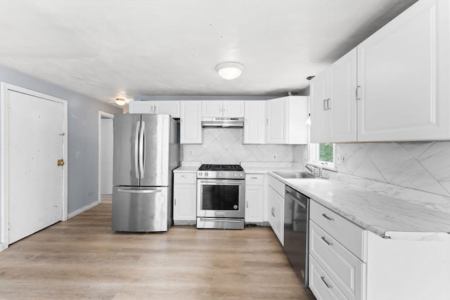 59 Harvard St, Everett, MA 02149 - kitchen featuring stainless steel appliances, under cabinet range hood, a sink, white cabinets, and decorative backsplash