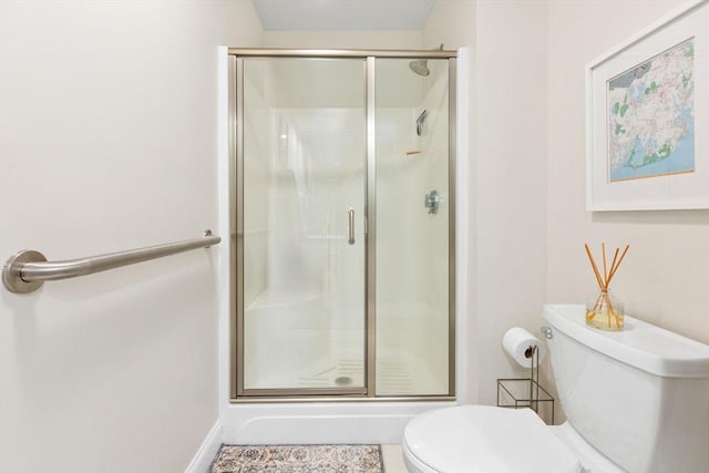 full bathroom with baseboards, toilet, and a stall shower