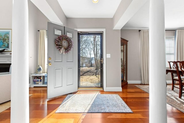 foyer entrance with ornate columns, baseboards, and hardwood / wood-style floors