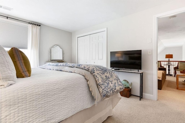 carpeted bedroom featuring baseboards, visible vents, and a closet