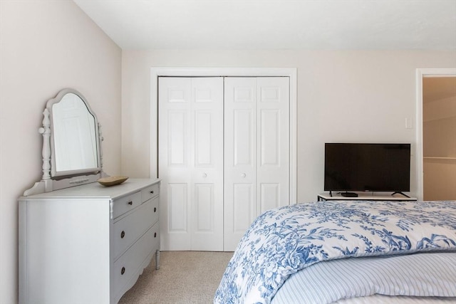 bedroom featuring light carpet and a closet