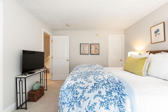 bedroom with baseboards and light colored carpet