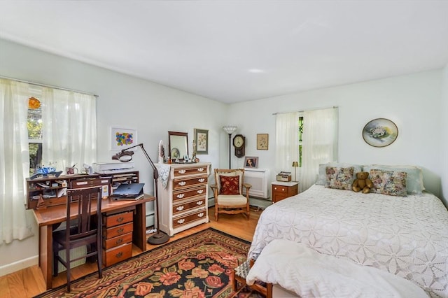 bedroom with wood finished floors and an office area