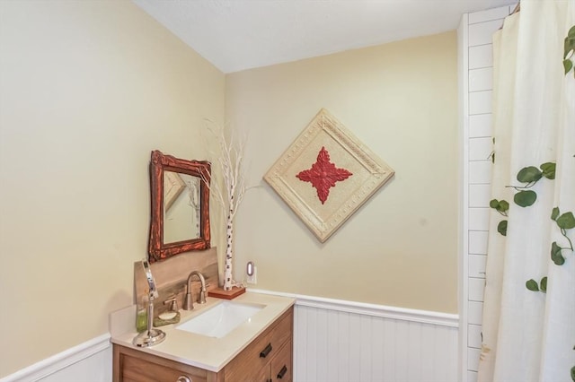 full bathroom featuring a wainscoted wall, vanity, and a shower with curtain
